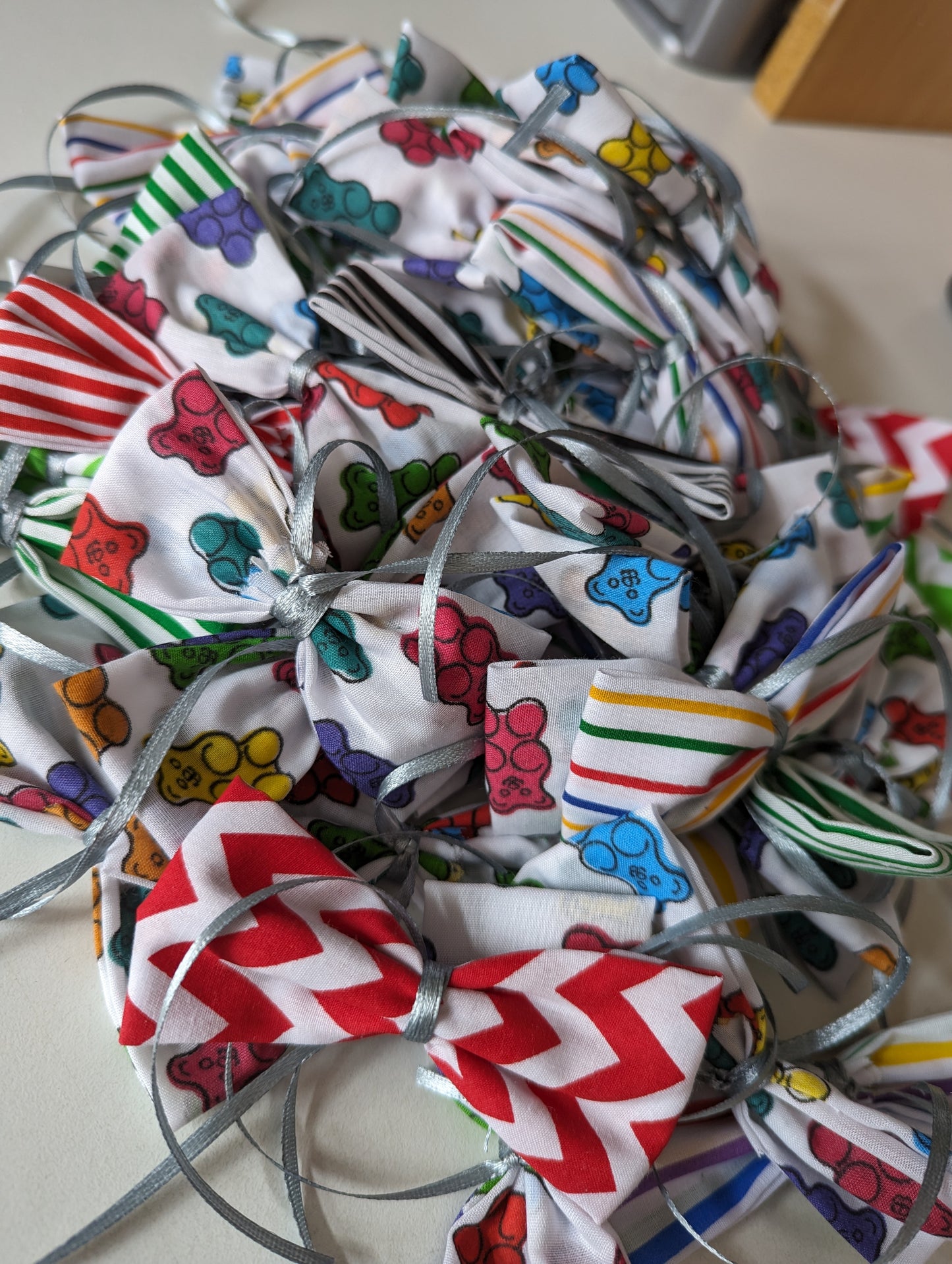 A collection of colorful sweetheart dog grooming bows with ribbon centers, displayed in varying colors including purple, green, and pink, with a polka dot pattern.
